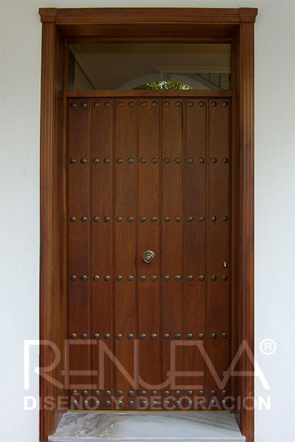 puerta de entrada fabricada a medida en madera de iroko con clavos